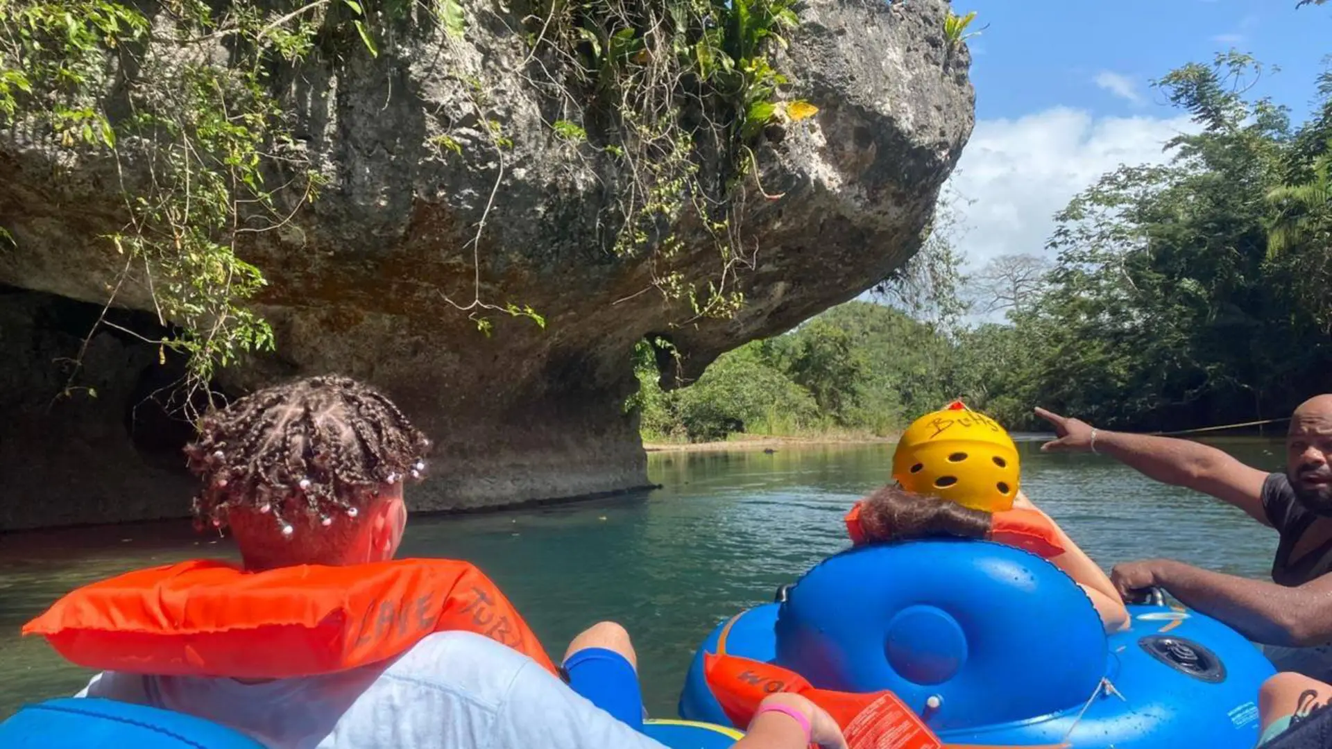 Cave-Tubing.Com - Tourists enjoying a guided cave tubing adventure on a river through lush jungle caves in Belize