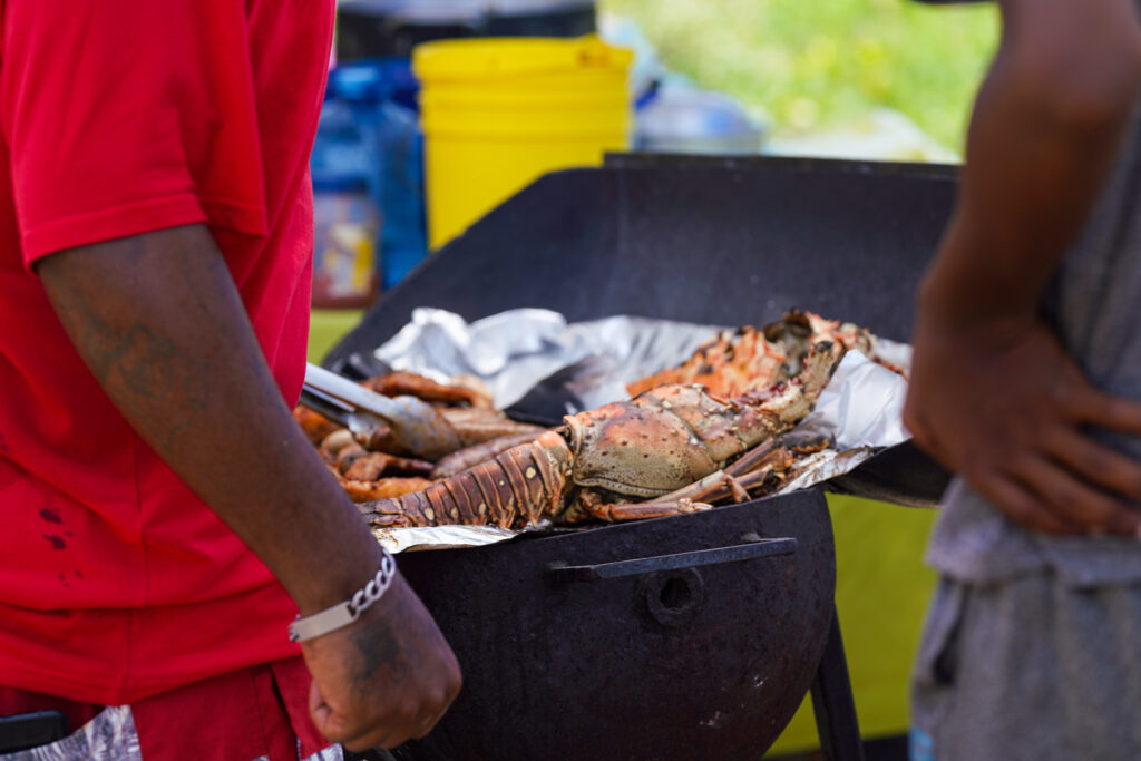 Einheimische in Belize bereiten beim Belize Lobster Festival gegrillten Hummer zu