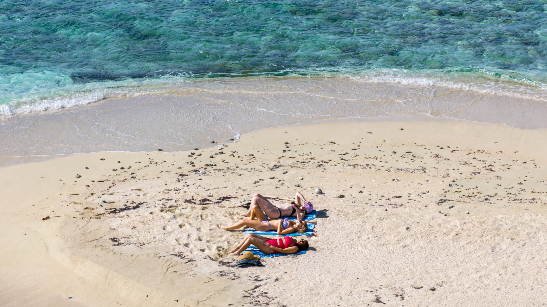 women relaxing on a sand bar in Belize